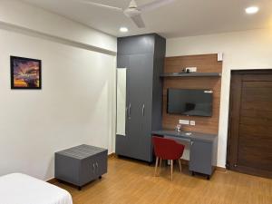 a bedroom with a bed and a desk and a tv at Palladium Luxury Suites Financial District Unit II in Hyderabad