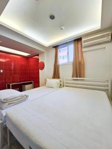 2 Betten in einem Zimmer mit roten Fliesen in der Unterkunft Travelers A Korea Hostel in Seoul