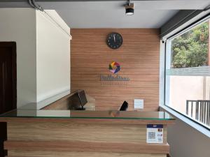 a reception desk with a clock on a wall at Palladium Luxury Suites Financial District Unit II in Hyderabad
