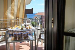 - une table sur un balcon avec de la nourriture dans l'établissement LA CASA SUL PORTICCIOLO - STAZZO, à Acireale