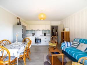 een woonkamer met een tafel en een blauwe bank bij Apartment Le Marbello by Interhome in Le Lavandou