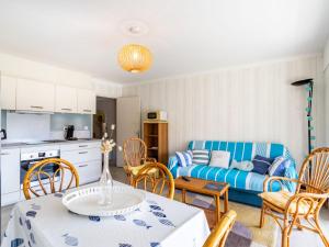 uma cozinha e uma sala de estar com mesa e cadeiras em Apartment Le Marbello by Interhome em Le Lavandou
