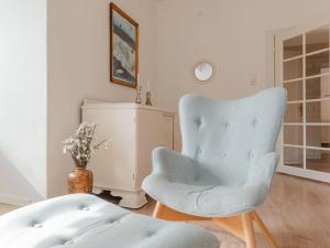 a living room with a blue chair and a table at Apartment Schubert-5 by Interhome in Bad Gastein