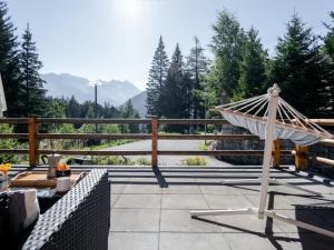 a hammock on a patio with mountains in the background at Chalet Mon Rêve by Interhome in Champex