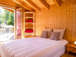 ein Schlafzimmer mit einem Bett in einer Holzwand in der Unterkunft Chalet Mon Rêve by Interhome in Champex