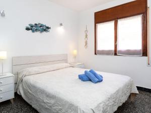 Un dormitorio con una cama con dos almohadas azules encima. en Apartment Edificio Beausoleil by Interhome, en Hospitalet de l'Infant