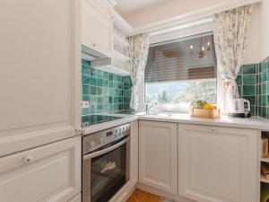 eine Küche mit weißen Schränken und einem Fenster in der Unterkunft Apartment Schbert-Franz Top 12 by Interhome in Bad Hofgastein