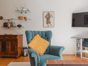 een blauwe stoel met een geel kussen in de woonkamer bij Apartment Murmeltier by Interhome in Bad Gastein