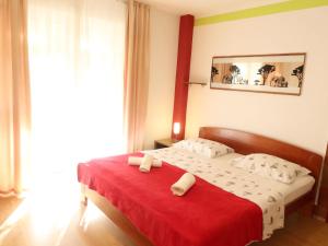 Un dormitorio con una cama con una manta roja. en Apartment Zorić by Interhome, en Privlaka