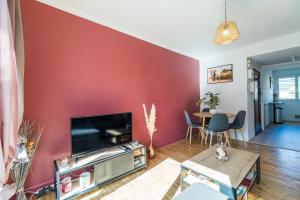 uma sala de estar com uma parede de acento vermelho em T3 rénové avec balcon et parking - Saint-brieuc em Saint-Brieuc