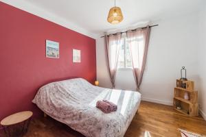 1 dormitorio con cama y pared roja en T3 rénové avec balcon et parking - Saint-brieuc en Saint-Brieuc