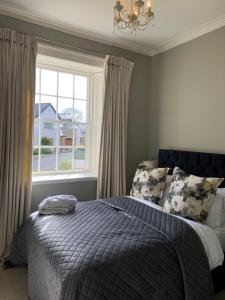 a bedroom with a bed with a blue comforter and a window at Penthouse apartment in Cockermouth