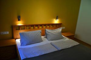 ein Bett mit zwei blauen und weißen Kissen darauf in der Unterkunft Ferienstadl - Hammerau in Göstling an der Ybbs