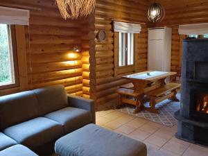a living room with a couch and a table in a log cabin at Holiday Home Purnutar b by Interhome in Kolinkylä