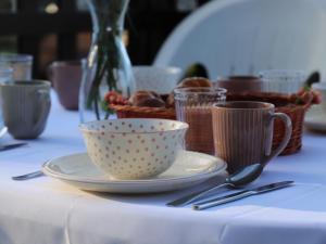 una mesa con un plato, tazas y cucharas en Chalet Ushuaia by Interhome, en Nendaz 35 fotos más