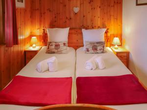 Un dormitorio con dos camas con sábanas rojas y blancas. en Chalet Ushuaia by Interhome, en Nendaz