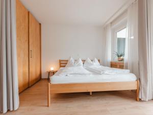 a bedroom with a bed with white sheets and a window at Apartment Hasennest by Interhome in Bad Hofgastein