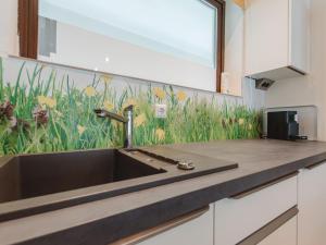 a kitchen sink with a mural of flowers on the wall at Apartment Hasennest by Interhome in Bad Hofgastein