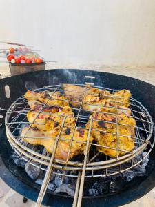 a bunch of food cooking on a grill with chopsticks at بيت جرش - Jerash House in Jerash +33 photos