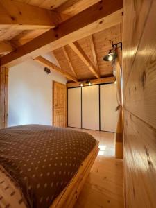 ein Schlafzimmer mit einem Bett in einem Holzzimmer in der Unterkunft Hiška Erika - Wood House Erika in Šoštanj