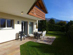 een patio met een tafel en stoelen op een gazon bij Holiday Home Maison N-35 by Interhome in Bluche