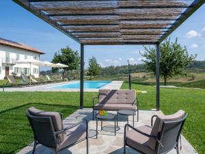eine Terrasse mit Stühlen, einem Tisch und einem Pool in der Unterkunft Holiday Home Casa Faretto - Monviso by Interhome in Costigliole dʼAsti