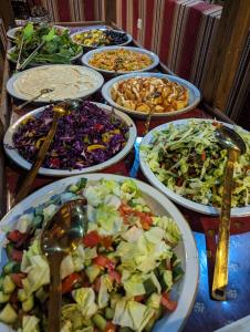 a table with many plates of different types of food at Desert Magic Camp & Resort in Wadi Rum