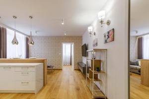 a kitchen and living room with white cabinets and wood floors at FLORENCJA - nowy apartament w centrum miasta z KLIMATYZACJĄ oraz zadaszonym parkingiem w cenie in Nowy Targ