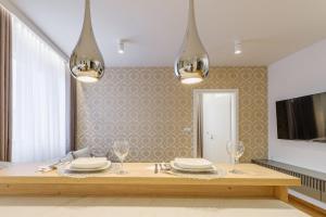 a dining room with a table with plates and glasses at FLORENCJA - nowy apartament w centrum miasta z zadaszonym parkingiem w cenie in Nowy Targ