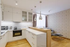 a kitchen with white cabinets and a counter top at FLORENCJA - nowy apartament w centrum miasta z zadaszonym parkingiem w cenie in Nowy Targ