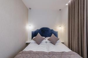a bedroom with a bed with a blue headboard and pillows at FLORENCJA - nowy apartament w centrum miasta z zadaszonym parkingiem w cenie in Nowy Targ