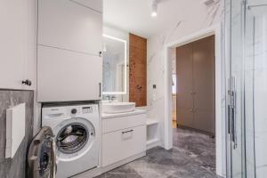 a white laundry room with a washer and dryer at FLORENCJA - nowy apartament w centrum miasta z zadaszonym parkingiem w cenie in Nowy Targ