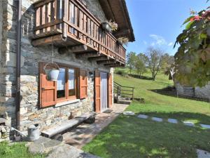 a stone house with orange doors and a window at Chalet Baita Lake View in Poira di Dentro