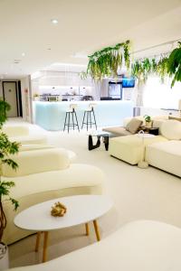 a living room with white couches and tables at Wonderwall Ximending in Taipei