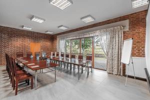 Dom Pracy Twórczej في يونيجوو: قاعة اجتماعات مع طاولة وكراسي وجدار من الطوب
