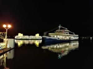 Nachts liegt ein Boot im Wasser. in der Unterkunft Apartment Luxury Sunrise by Interhome in Pörtschach am Wörthersee