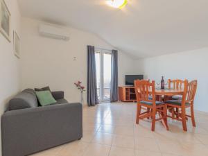 ein Wohnzimmer mit einem Sofa, einem Tisch und Stühlen in der Unterkunft Apartment Irena-3 by Interhome in Privlaka