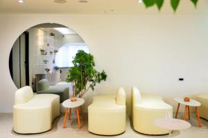 a waiting room with white chairs and tables at Wonderwall Ximending in Taipei