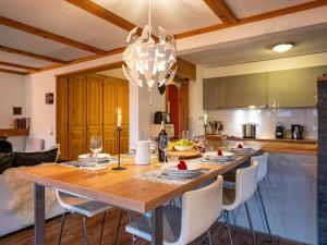 een keuken met een grote houten tafel met stoelen bij Apartment Hyacinthe by Interhome in Villars-sur-Ollon