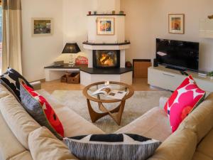 sala de estar con sofá y chimenea en Apartment Les Cîmes by Interhome, en Gryon