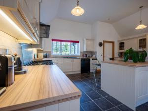een keuken met witte kasten en een houten aanrecht bij Holiday Home Strathmore Lodge by Interhome in Whitebridge