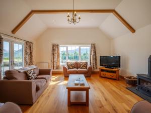 een woonkamer met een bank en een tv bij Holiday Home Strathmore Lodge by Interhome in Whitebridge