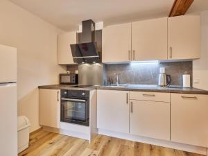 a kitchen with white cabinets and a stove top oven at Apartment Stela by Interhome in Bolkov