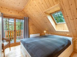 a bedroom in a log cabin with a bed and windows at Chalet Schwabenhütte by Interhome in Sirnitz-Sonnseite