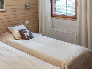 ein Schlafzimmer mit einem Bett und einem Kissen darauf in der Unterkunft Holiday Home Länsirinne e 19 by Interhome in Ruka + 8 Fotos