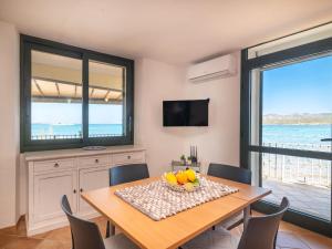 una sala da pranzo con un tavolo con sedie e una televisione di Apartment Donatella by Interhome a Cannigione