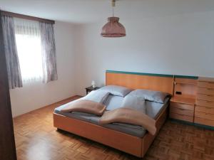 a bedroom with a bed with a wooden headboard at Holiday Home Lama by Interhome in Niederwölz