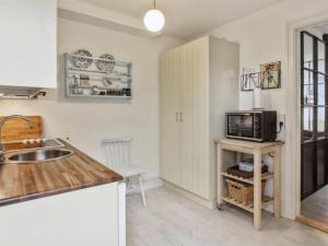 a kitchen with a sink and a microwave at Apartment Marisol - 700m from the sea in NW Jutland by Interhome in Skagen