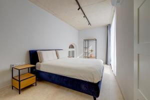 um quarto branco com uma cama grande e uma janela em Seafront Traditional Maltese Townhouse Balluta Bay em Sliema