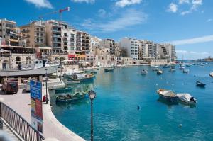 斯利馬的住宿－Seafront Traditional Maltese Townhouse Balluta Bay，城市中一条有船的河流